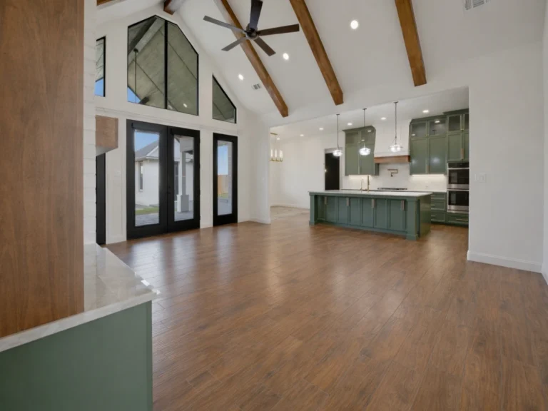 Custom home interior with open-concept living space, wood beam ceiling, and custom kitchen cabinets in Midland, TX