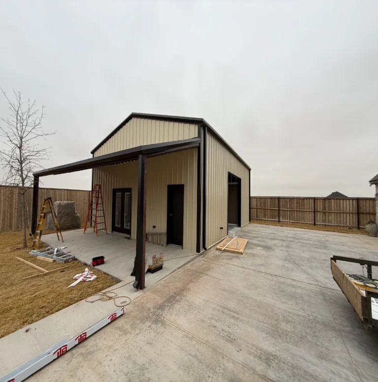 Large-scale metal building frame under construction with red steel panels by Crystal Cabinets Inc., Midland TX