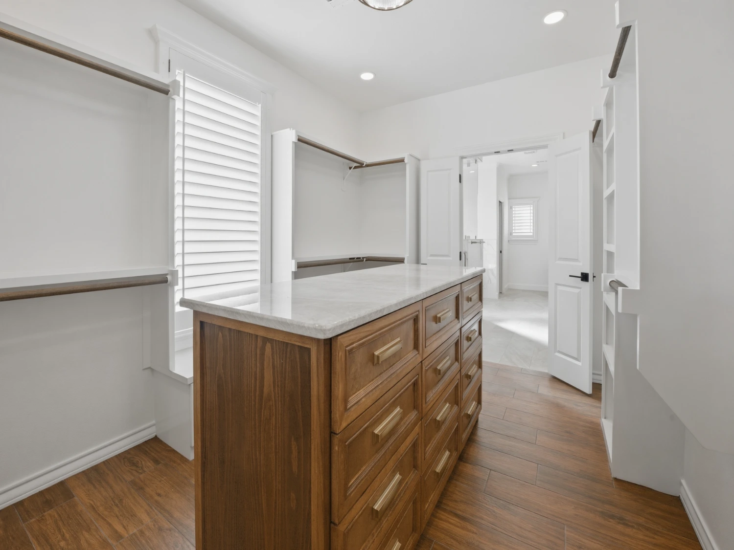 Wood custom cabinetry island with granite countertop in a walk-in closet, Midland TX
