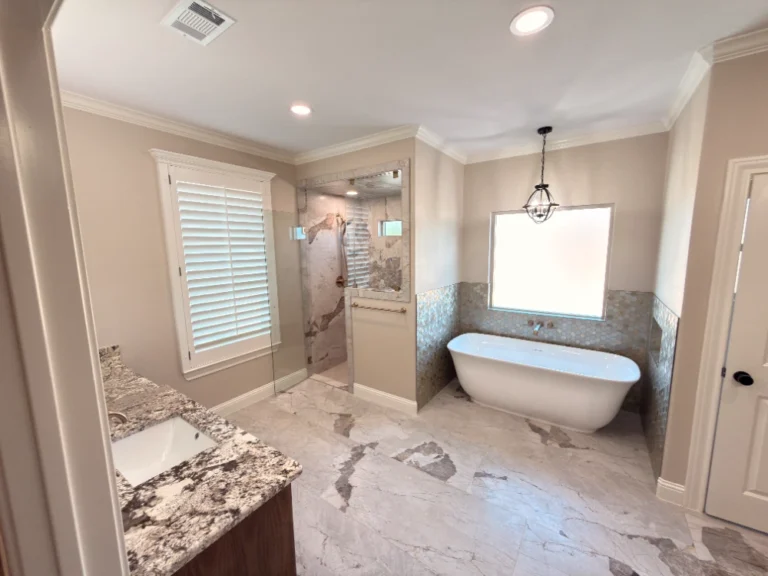 Luxury bathroom remodel with freestanding bathtub, marble tile flooring, walk-in shower, and granite vanity in Midland, TX