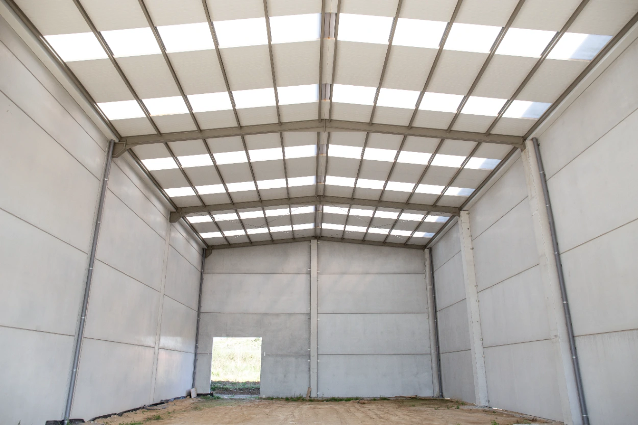 Interior of a steel frame metal building with exposed framing, insulated panels and translucent roof lighting in Midland TX