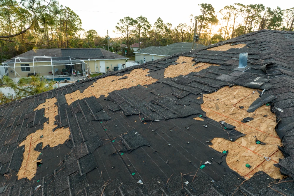 Wind damaged asphalt shingle roof with shingles stripped to the decking after a storm, needing repair in Midland TX
