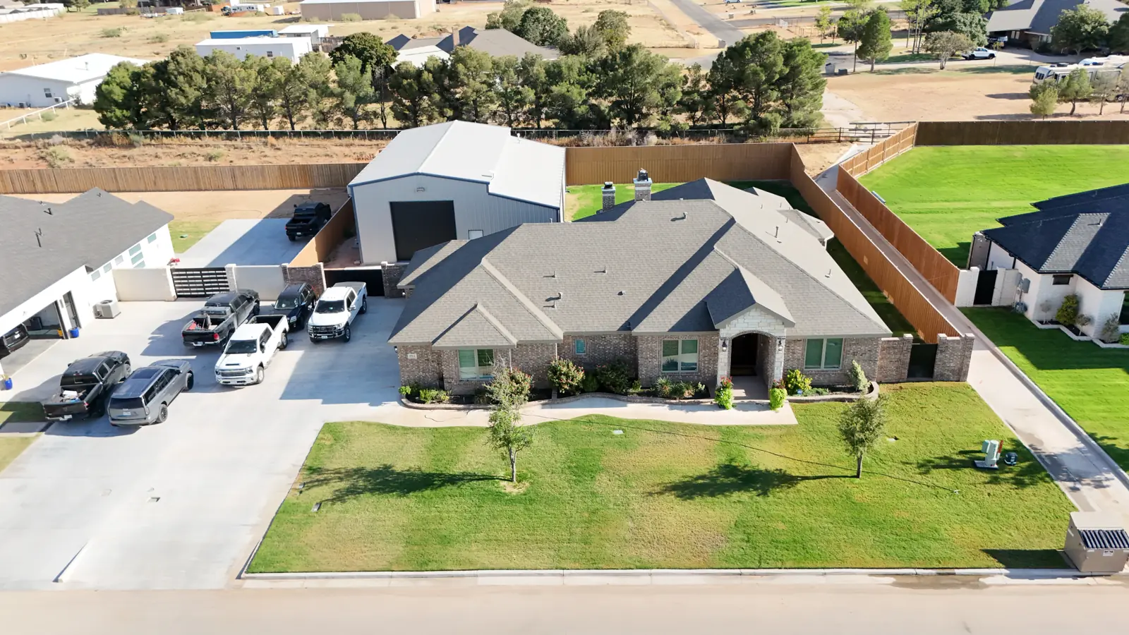 Custom home with a large metal building behind it in Saddleback Estates